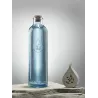 Bouteille OmWater Gratitude 1,2 L à côté d'une goutte en pierre sculptée du symbole Om