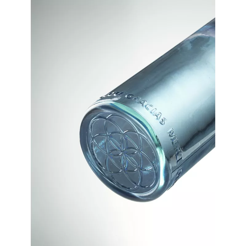Fond d'une bouteille OmWater : la graine de vie gravée dans le verre